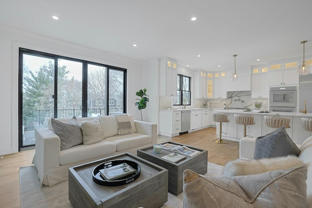 living room with light wood-type flooring and recessed lighting