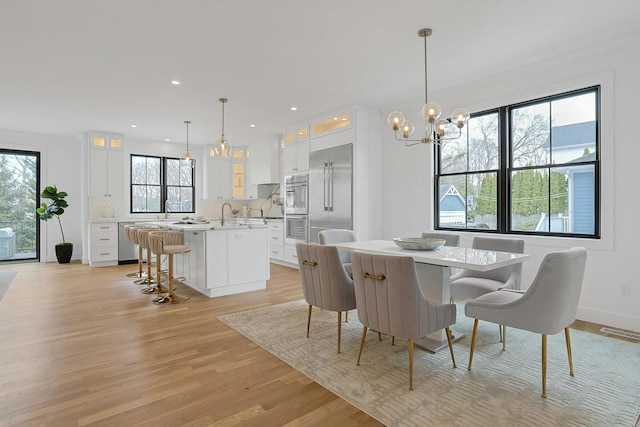 dining room with a notable chandelier, recessed lighting, visible vents, light wood-type flooring, and baseboards