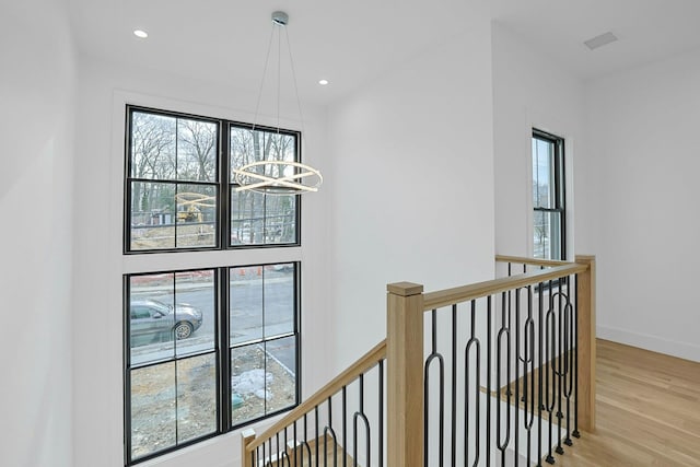 hall with a notable chandelier, recessed lighting, light wood-style flooring, an upstairs landing, and baseboards