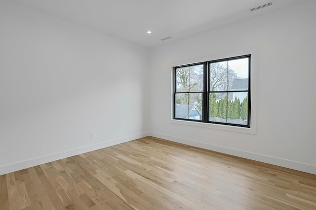 empty room featuring light wood-style floors, recessed lighting, visible vents, and baseboards