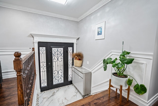 foyer entrance with ornamental molding and dark hardwood / wood-style floors