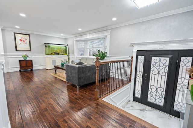 foyer entrance with ornamental molding and hardwood / wood-style floors