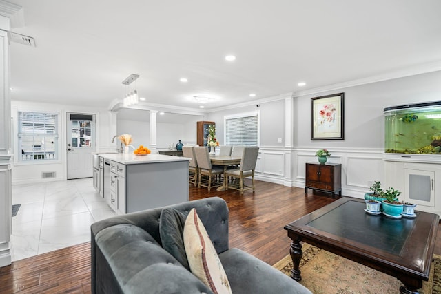 living room with crown molding, plenty of natural light, and sink