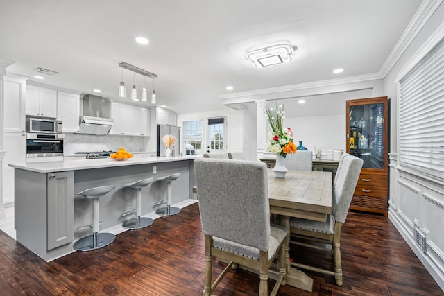 dining area featuring ornamental molding and dark hardwood / wood-style flooring