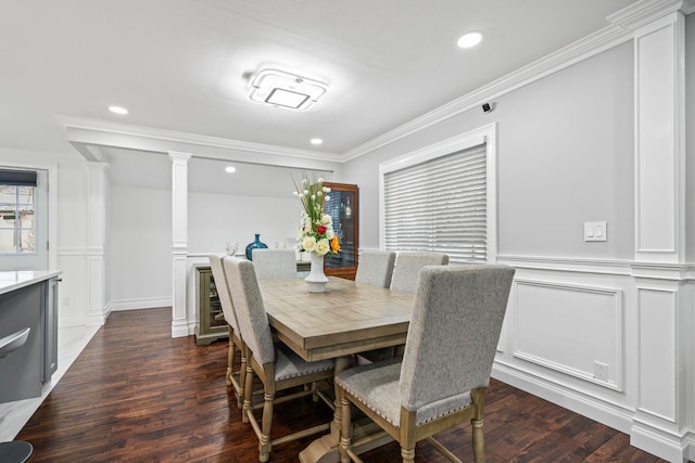 dining area with ornate columns, ornamental molding, and dark hardwood / wood-style floors