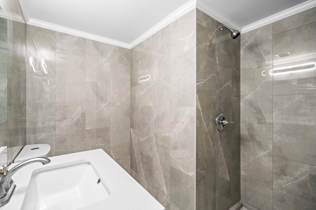 bathroom with ornamental molding, sink, a tile shower, and toilet