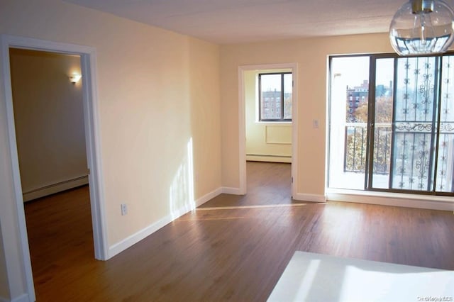 spare room featuring dark wood-type flooring and baseboard heating