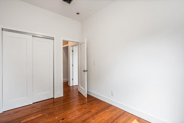 unfurnished bedroom featuring dark hardwood / wood-style flooring and a closet