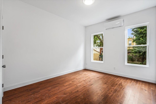 spare room featuring dark hardwood / wood-style floors and a wall mounted AC