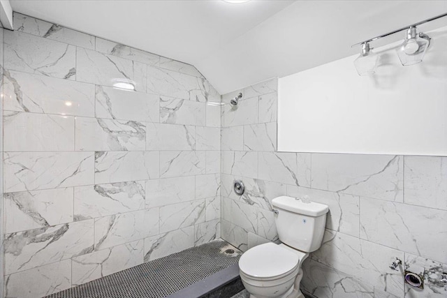 bathroom with vaulted ceiling, tiled shower, and toilet