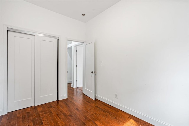 unfurnished bedroom featuring a closet and dark hardwood / wood-style floors