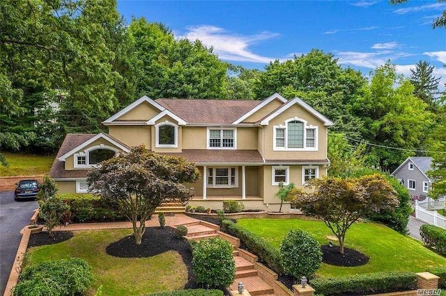 view of front of property with covered porch and a front lawn