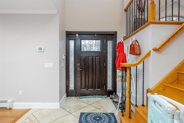 foyer entrance featuring a baseboard radiator, light tile patterned flooring, and crown molding