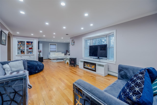 living room featuring crown molding, a baseboard radiator, and hardwood / wood-style floors