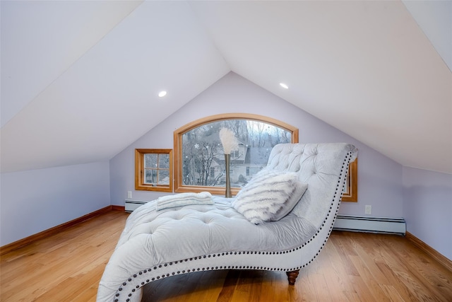 bedroom featuring vaulted ceiling, light hardwood / wood-style flooring, and a baseboard heating unit