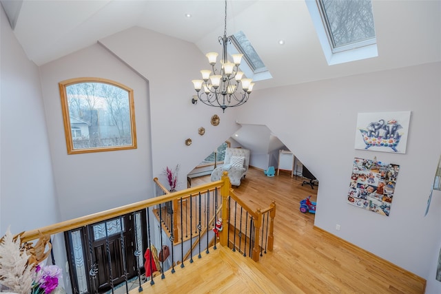 interior space with lofted ceiling with skylight, hardwood / wood-style floors, and a chandelier