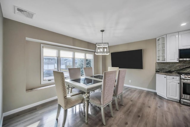 dining area featuring hardwood / wood-style floors and a notable chandelier