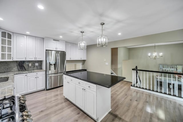 kitchen featuring white cabinetry, stainless steel fridge with ice dispenser, light hardwood / wood-style floors, and hanging light fixtures