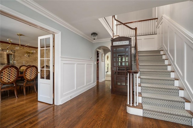 entryway with crown molding and dark wood-type flooring