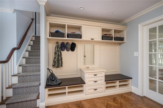 mudroom with dark parquet flooring and crown molding