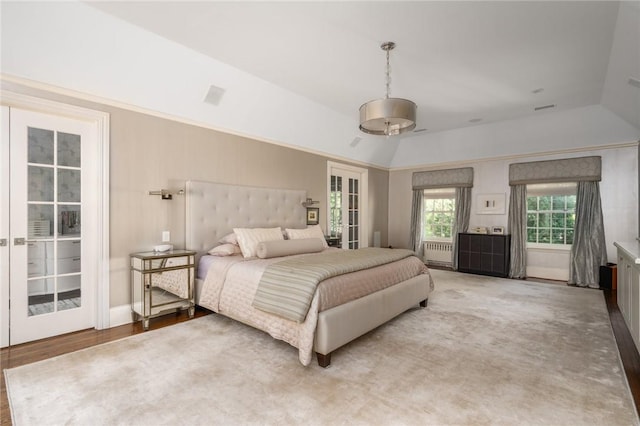 bedroom featuring wood-type flooring, lofted ceiling, and french doors