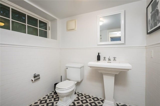 bathroom with tile walls and toilet