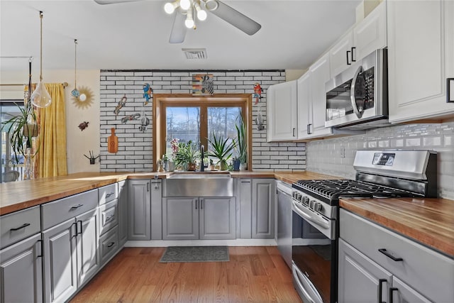 kitchen featuring wood counters, white cabinetry, gray cabinets, and stainless steel appliances