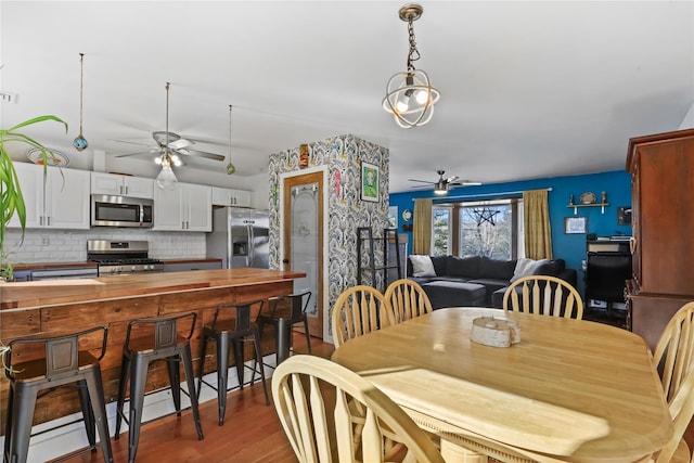 dining space featuring ceiling fan and light wood-type flooring