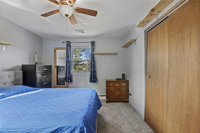 bedroom with a baseboard heating unit, ceiling fan, and carpet