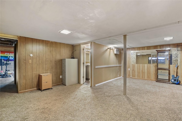 basement featuring light colored carpet and wood walls