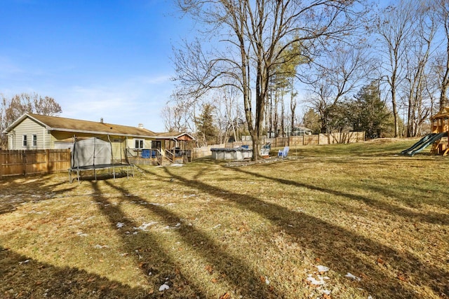 view of yard featuring a playground and a trampoline