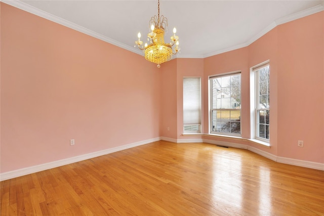 empty room featuring crown molding, a chandelier, and light hardwood / wood-style floors