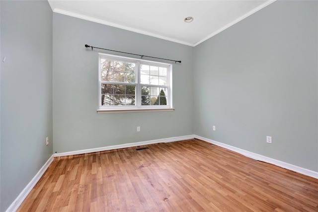 unfurnished room with ornamental molding and light wood-type flooring