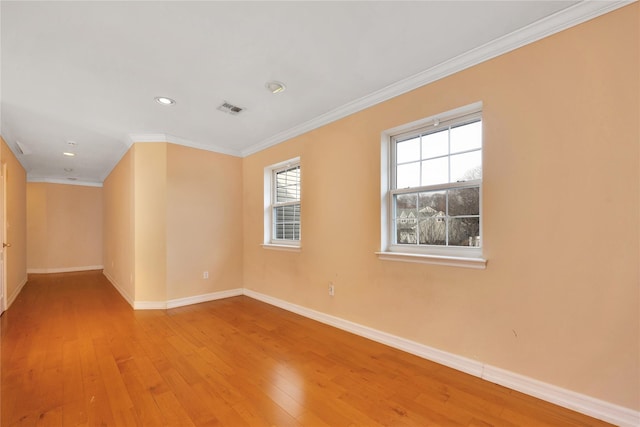 empty room featuring crown molding and light hardwood / wood-style floors