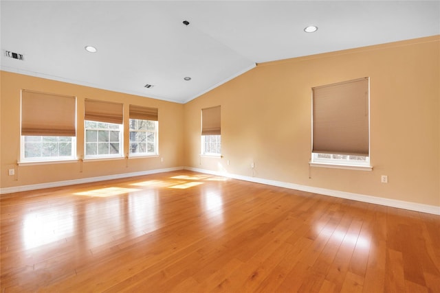 spare room featuring ornamental molding, lofted ceiling, and light hardwood / wood-style flooring