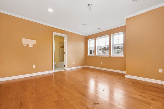 empty room featuring ornamental molding and light wood-type flooring