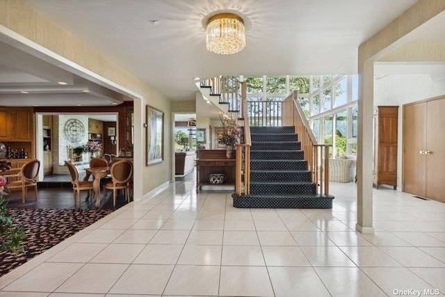 stairway with a notable chandelier and tile patterned floors