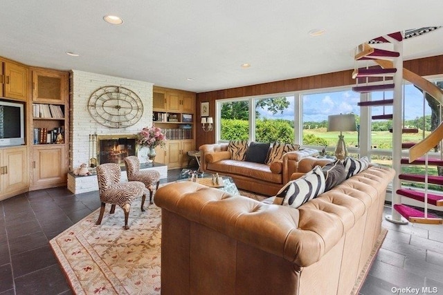 living room with a brick fireplace and built in shelves