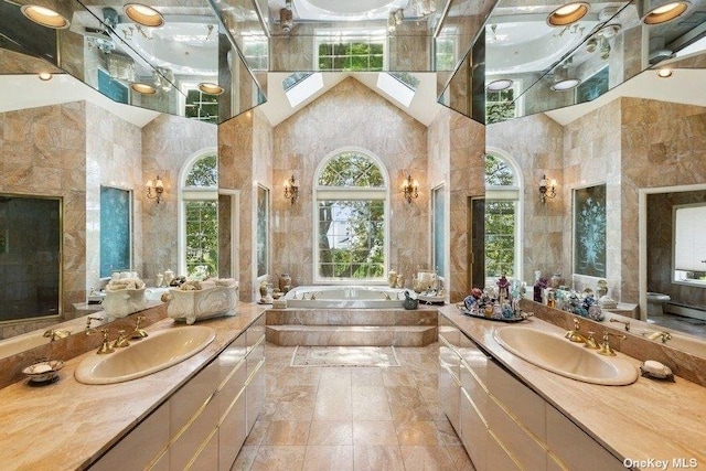 bathroom with a towering ceiling, vanity, and tiled bath