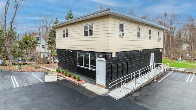 view of home's exterior featuring uncovered parking and cooling unit