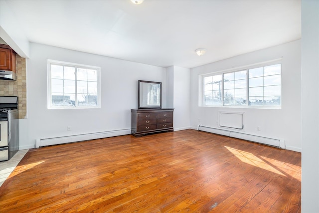 unfurnished living room featuring light hardwood / wood-style flooring and baseboard heating