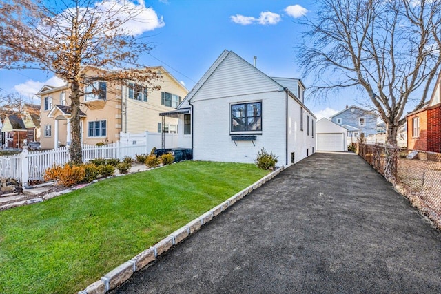 view of front of house with a garage, an outdoor structure, and a front lawn