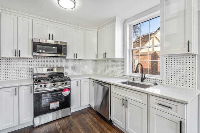 kitchen with sink, backsplash, stainless steel appliances, dark hardwood / wood-style floors, and white cabinets