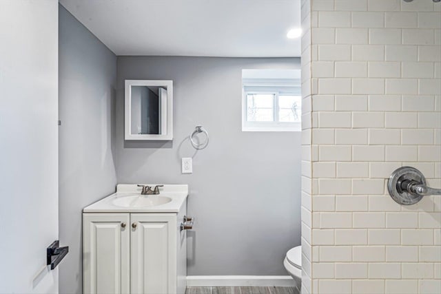 bathroom with vanity, wood-type flooring, toilet, and walk in shower