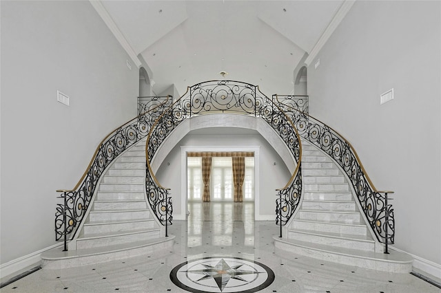 staircase with crown molding and a high ceiling