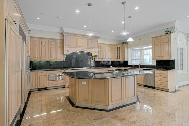 kitchen with an island with sink, stainless steel dishwasher, light brown cabinetry, and decorative light fixtures