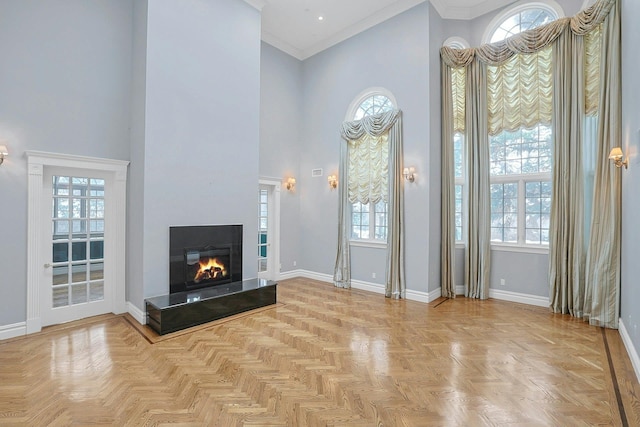 unfurnished living room featuring a high ceiling, crown molding, and parquet floors