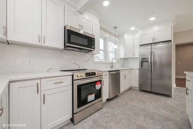 kitchen with white cabinetry, stainless steel appliances, light stone counters, tasteful backsplash, and decorative light fixtures