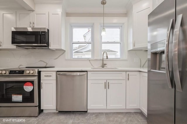 kitchen with sink, white cabinetry, crown molding, hanging light fixtures, and stainless steel appliances