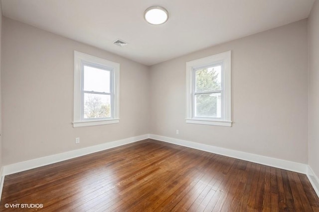 unfurnished room with dark hardwood / wood-style flooring and a wealth of natural light